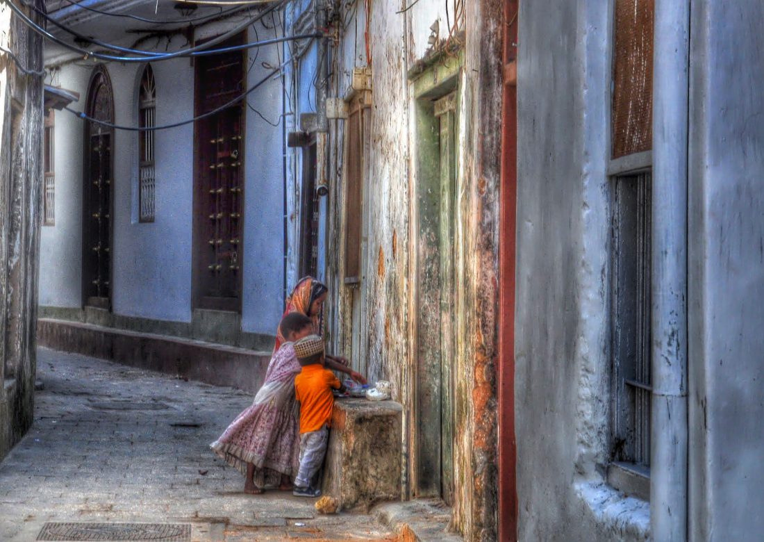 Narrow winding street in Stone Town with coral stone walls and traditional architecture typical of the UNESCO World Heritage Site